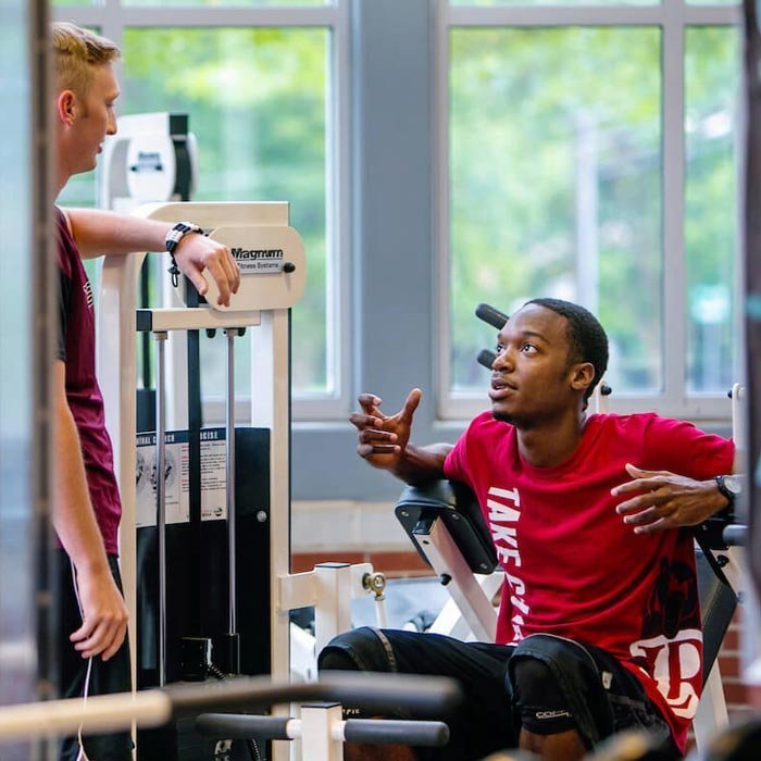 Two students talking in fitness center